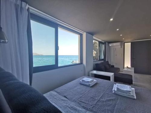 ParánimfoiSunrise Luxury Seaside Apartment的一间卧室设有一张床,享有海景