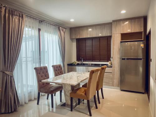 Ban Bang Toei (1)NP Krungthep Kreetha​ Villa的厨房配有桌椅和冰箱。