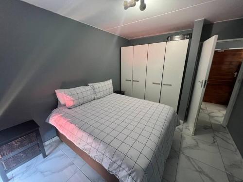 比勒陀利亚Beyond Comfort Apartment的一间带床和橱柜的小卧室