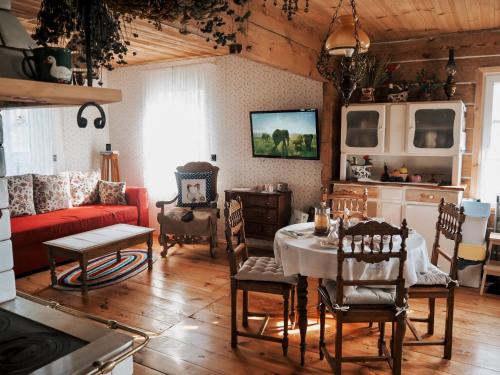 WyszkiNa wsi Zalesie 53的客厅配有红色的沙发和桌子