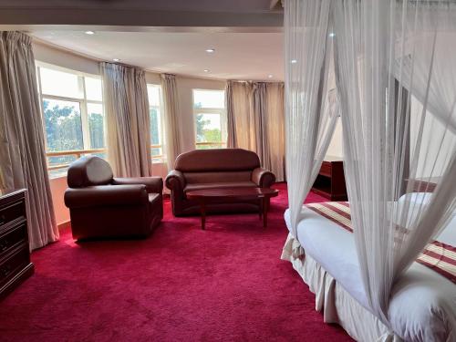 GuluBomah Hotel Limited的一间卧室配有一张床、一张沙发和一把椅子