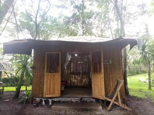 NyakinamaRed Rocks Rwanda - Bamboo Cottage的森林中带开放式门的小小屋