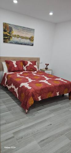 塞维利亚chalet El campillo的一间卧室配有一张带红白毯子的床