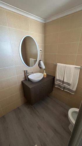 普拉亚达维多利亚Hortênsia's AL的一间带水槽、镜子和卫生间的浴室