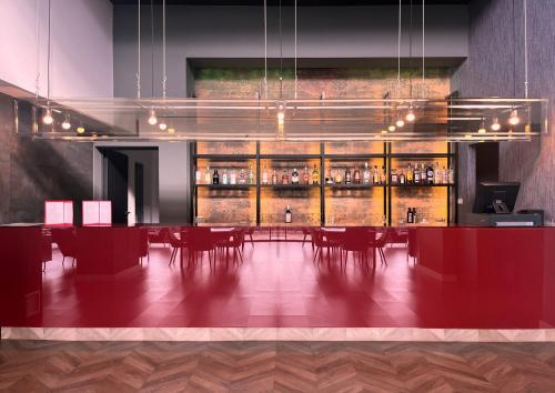 拉莫利纳HG拉莫利纳酒店的用餐室设有酒吧,配有红色的桌椅