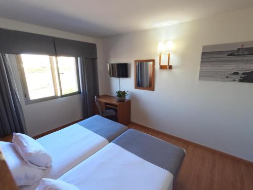 格拉纳达萨亚鲁酒店的酒店客房设有两张床和窗户。