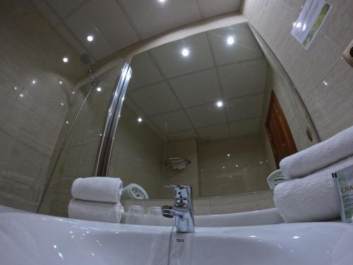 格拉纳达萨亚鲁酒店的浴室配有带镜子的盥洗盆和毛巾