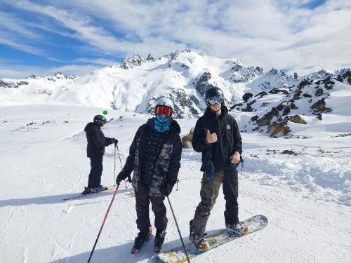埃博森Cabaña Los Lúpulos的三人在山地雪中滑雪