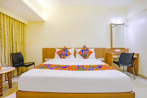 纳威孟买FabExpress Kuber的卧室配有一张带椅子和桌子的大床