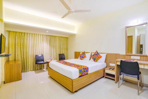 纳威孟买FabExpress Kuber的酒店客房配有一张床、一张书桌和一张四柱床