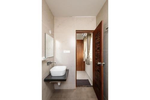 班加罗尔Olive Serviced Apartments BTM Layout的一间带水槽、卫生间和镜子的浴室