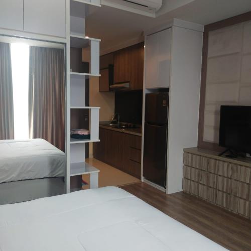 Sepinggang-besarApartemen Skylounge Balikpapan 2BR的酒店客房设有一张床、一台电视和一间卧室。