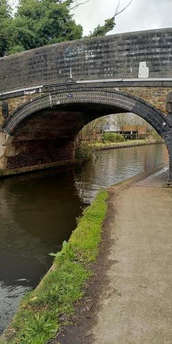 伦敦Boutique Canal Narrow Boat London的一条有路的河上的砖桥