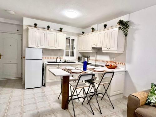 夏约法Piera's Apartment的厨房配有白色橱柜和桌椅