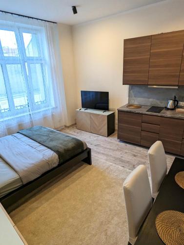 克拉科夫Apartament A3 in Downtown of Krakow的一间卧室配有一张床、一台电视和一张桌子