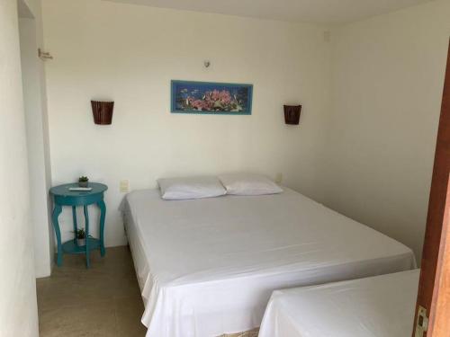 São Gonçalo do AmaranteCasa em resort na Taiba的卧室配有白色的床和蓝色的桌子