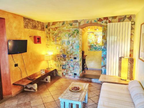 蒙泰斯库达伊奥Agriturismo Podere Santa Rita的客厅配有沙发和带壁画的墙壁