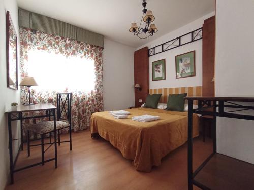 Poveda de la SierraHOSTAL RURAL ALTO TAJO POVEDA的一间卧室设有一张床、一个窗口和一张桌子