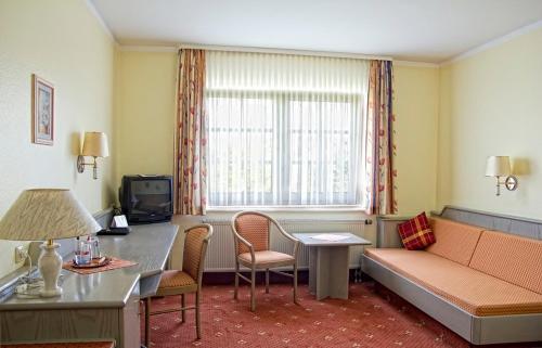 美因河畔法兰克福博格酒店的一间配有沙发、桌子和窗户的酒店客房