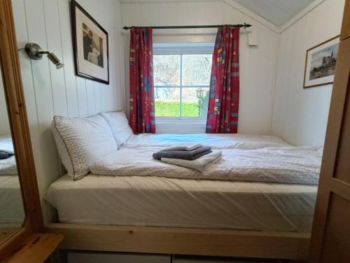 克里斯蒂安桑Guest house close to Kristiansand的窗户客房内的一张床位