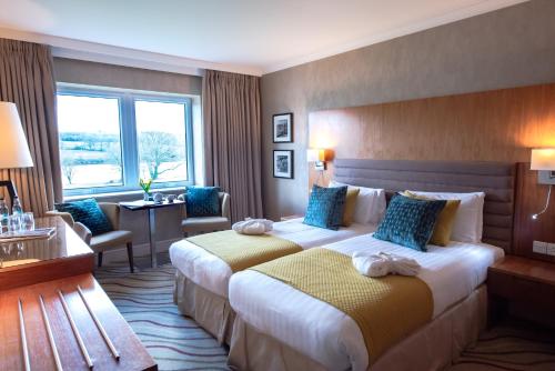 赖德湖畔公园酒店&SPA的酒店客房配有两张床和一张书桌