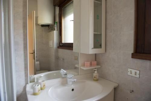 滕诺Appartamento Girasole con balcone e vista的浴室配有盥洗盆、镜子和浴缸