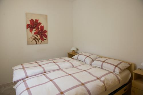 滕诺Appartamento Girasole con balcone e vista的卧室配有一张床,墙上挂有绘画作品