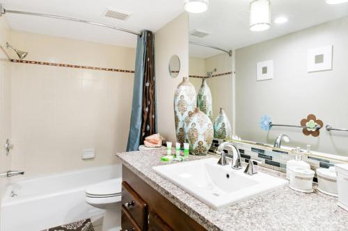 拉古纳海滩Unparalleled Villa Apartment in an Enchanting Village的一间带水槽、浴缸和卫生间的浴室