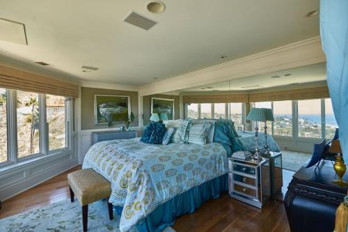 拉古纳海滩UNEQUALLED LUXURY VILLA BEACH 7000ft 180 VIEW的一间卧室配有一张带蓝色床罩的床和窗户