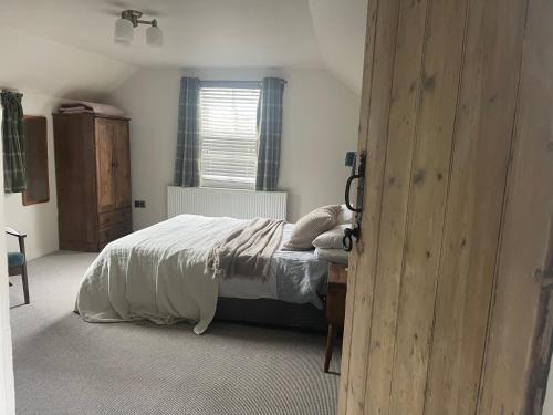 MoulinMoulin Cottage的一间卧室配有一张带白色床单的床和一扇窗户。