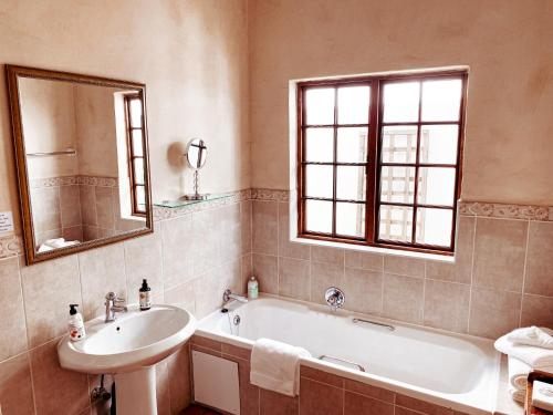 比勒陀利亚布鲁克斯住宿加早餐旅馆的带浴缸、水槽和镜子的浴室