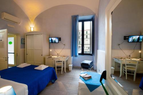 托雷安农齐亚塔Il Giardino di Tonia - Oplontis Guest House - Bed & Garden -的客房设有两张床、两张桌子和一扇窗户。