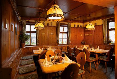 耶拿Altdeutsches Gasthaus Roter Hirsch的用餐室配有桌椅和吊灯。