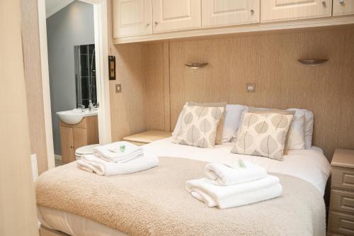 切斯特Recently updated lodge near Chester city centre - For up to 6的一间卧室配有带毛巾的床