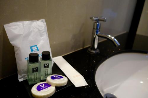 乌汶乌汶V酒店的一间带盥洗盆和台面洗浴用品的浴室