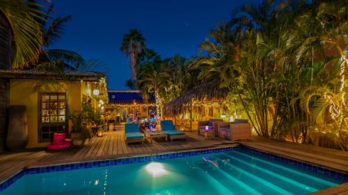 克拉伦代克Casa Calexico的游泳池,晚上设有蓝色椅子和棕榈树