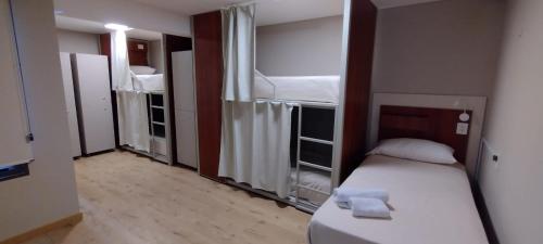 门多萨Nómade Hostel mdz的小房间设有一张床和两张双层床