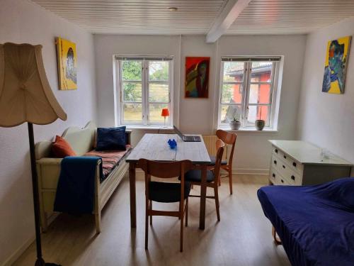 阿灵厄Rummeligt byhus i Allinge med værelse i stueplan og havkig的客房设有桌子、床和桌椅。