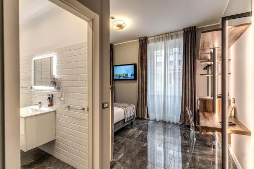 罗马Apollo Boutique Hotel的浴室设有床、水槽和镜子
