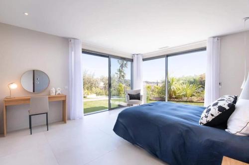 圣马克西姆Villa L, Vue mer, plage 10 min à pied的卧室配有一张床、一张书桌和窗户。