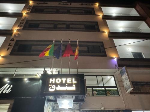 达赫拉Hotel Ahmed Ali的挂在建筑物上的挂有旗帜的酒店标志