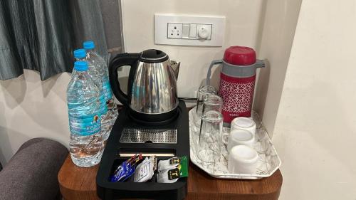 德奥加尔Hotel Omkareshwar Inn的桌子上配有咖啡壶和瓶装水