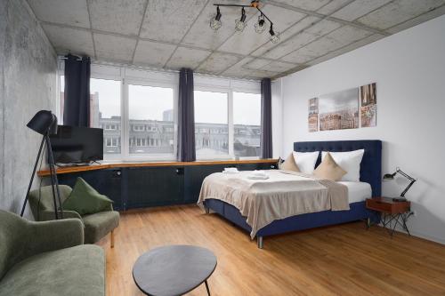 莱比锡Stylisches Studio im Herzen Leipzigs的一间卧室配有一张床、一张沙发和一台电视。