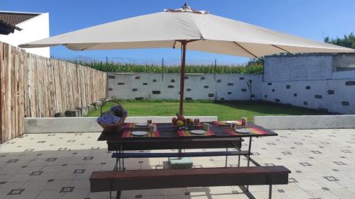 莫什泰鲁什WelcomeBuddy - Mosteiros Vineyards (Praia&Sunset)的天井上带遮阳伞的野餐桌