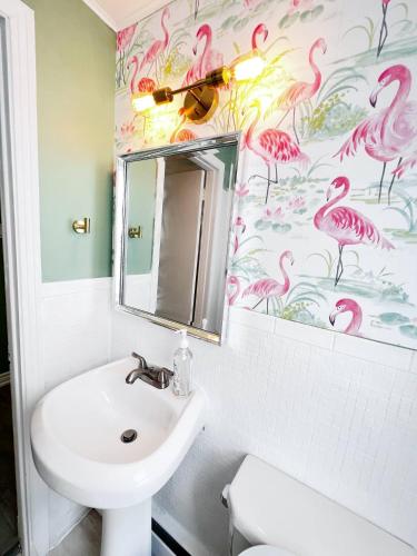 弗雷德里克顿The Hollywood Suite Downtown, BeverlyHills Vibe的浴室设有水槽和粉红色火烈鸟壁纸