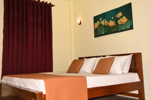 阿努拉德普勒Leaf Dew Resort的一间卧室配有一张带红色窗帘的床