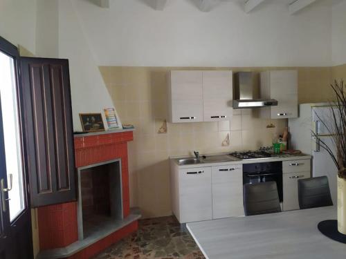 卡斯特里尼亚诺德尔卡波Villetta Municipio的厨房配有白色橱柜和炉灶烤箱。