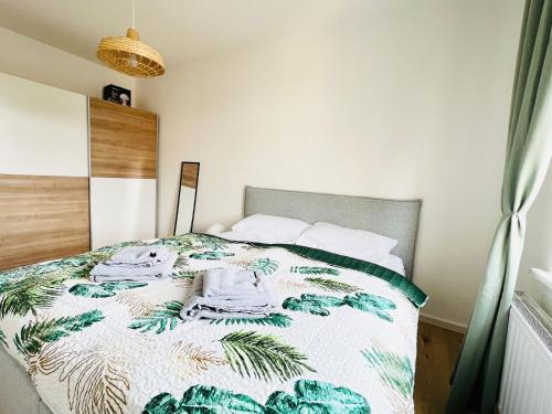 海德瑙Twenty Five Apartment的一间卧室配有一张带绿色和白色棉被的床