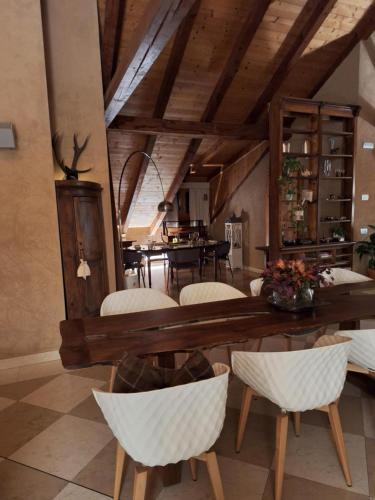 阿维奥Vallarom的一间带木桌和白色椅子的用餐室