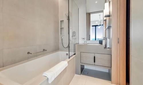 迪拜Address Beach JBR Apartment的白色的浴室设有浴缸和水槽。